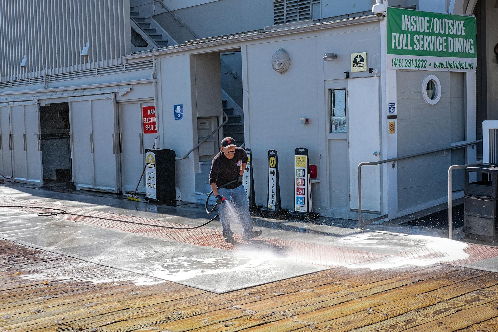 Commercial sidewalk being pressure washed during a cleaning service